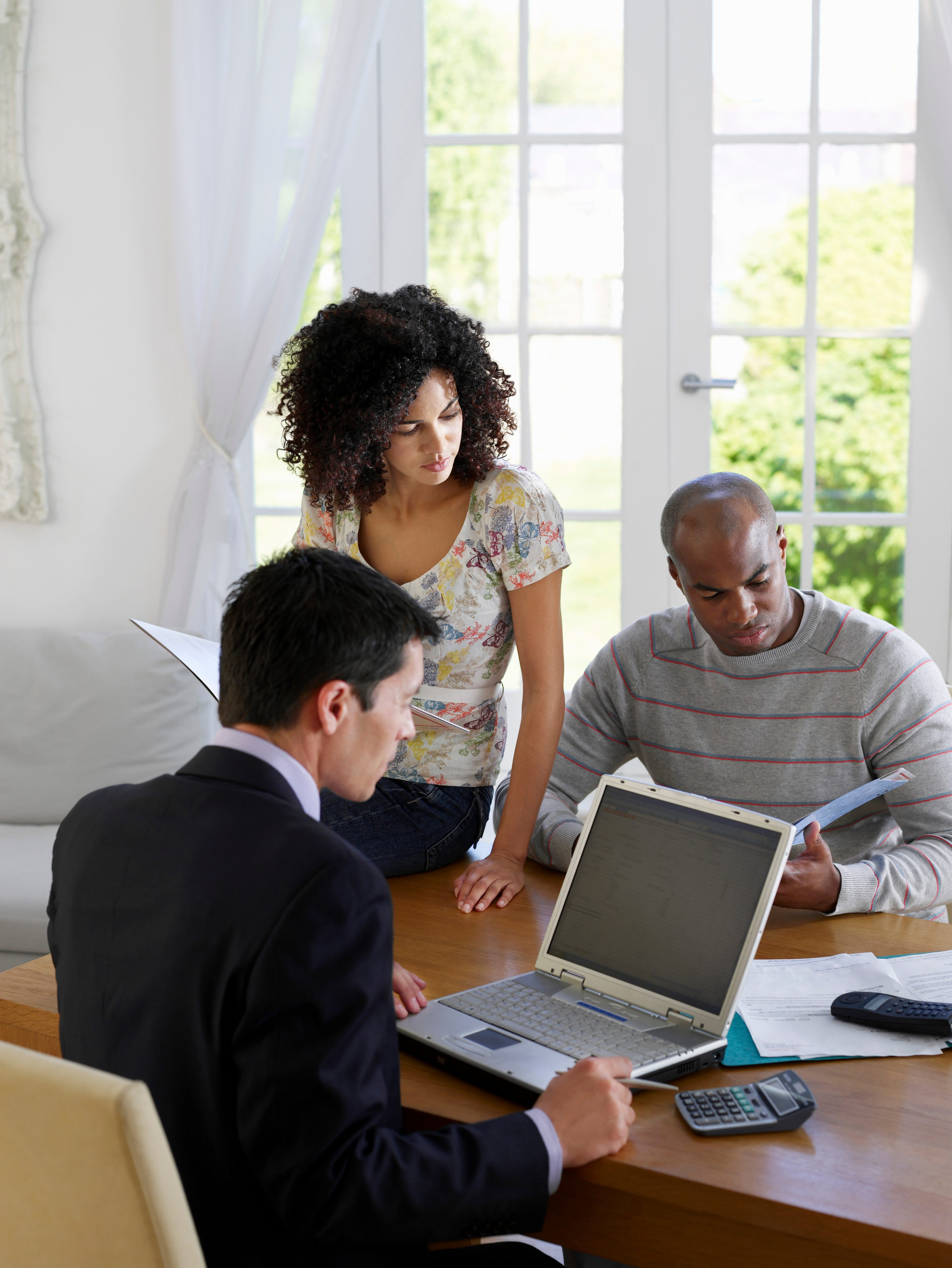 African American couple sitting at dining table with financial advisor